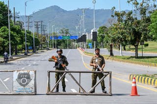 Police personnel stand guard at a closed road leading to the Serena Hotel in the Red Zone area of Islamabad on April 19, 2026. A second round of talks between the United States and Iran is expected in Islamabad this coming week.